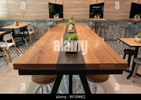 Bangkok, Thaïlande - 14 déc 2018 : grande table en bois avec des chaises et des plantes en décoration cafe Banque D'Images