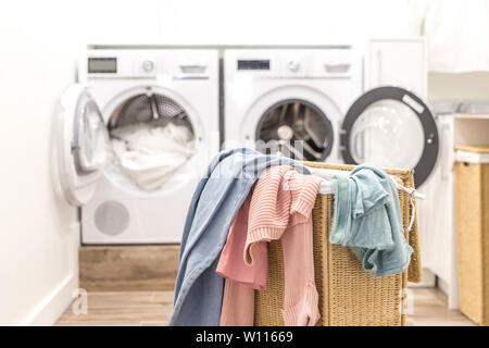 Buanderie avec lave-linge et sèche et panier de machines virtuelles sur arrière-plan Banque D'Images