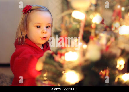 Girl in red décore l'arbre de Noël. concept de Noël Banque D'Images