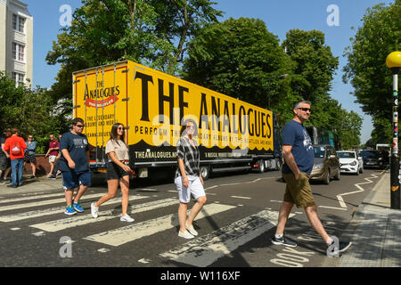 Abbey Road, Londres, Royaume-Uni. 29 juin 2019. Météo France : touristes traversant le célèbre passage piéton d'Abbey Road, rendue célèbre par les Beatles sur une brulante journée à Londres. Un camion est garé sur la route qui a la publicité sur elle pour 'les analogues' encore de Beatles. Crédit photo : Graham Hunt la photographie. Credit : Graham Hunt/Alamy Live News Banque D'Images