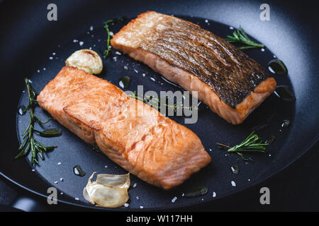 Darnes de saumon grillées dans une poêle avec l'ail et le romarin. Concept de saine alimentation. Banque D'Images