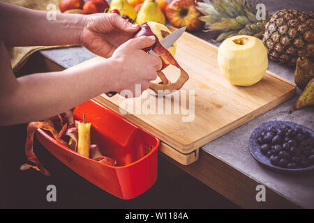 Les mains fraîches Bio Peeling Apple avec un petit couteau. La saine alimentation Vegan Raw Food Concept. Banque D'Images