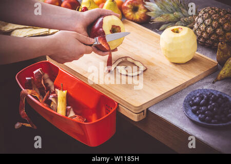 Les mains fraîches Bio Peeling Apple avec un petit couteau. La saine alimentation Vegan Raw Food Concept. Banque D'Images