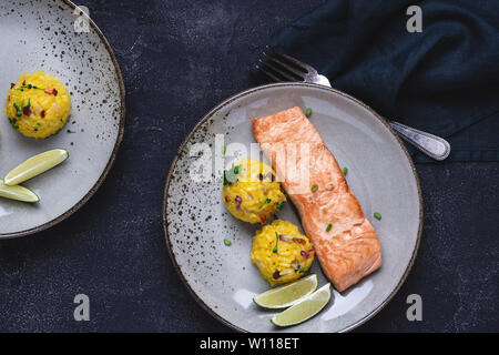 Pavé de saumon grillé avec risotto jaune et citron vert sur fond de Pierre. Concept de saine alimentation. Banque D'Images