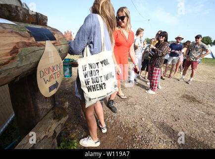 Les festivaliers en attente à un point de remplissage d'eau au festival de Glastonbury, en digne ferme dans Pilton, Somerset. Banque D'Images