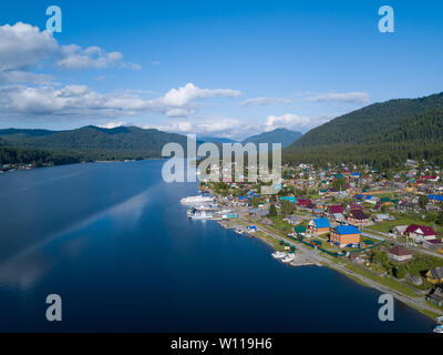 Vue aérienne de l'embouchure dans le lac Teletskoye large dans les montagnes de l'Altaï par l'eau, bleu ciel avec des nuages blancs, vert des arbres sur les pentes de l'un des roches Banque D'Images