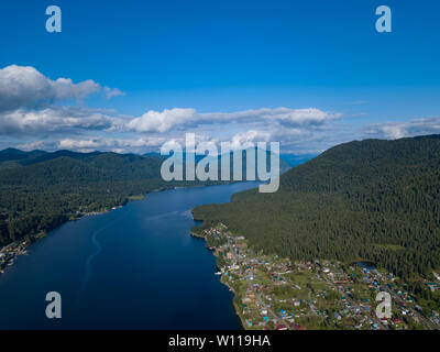 Vue aérienne de l'embouchure dans le lac Teletskoye large dans les montagnes de l'Altaï par l'eau, bleu ciel avec des nuages blancs, vert des arbres sur les pentes de l'un des roches Banque D'Images