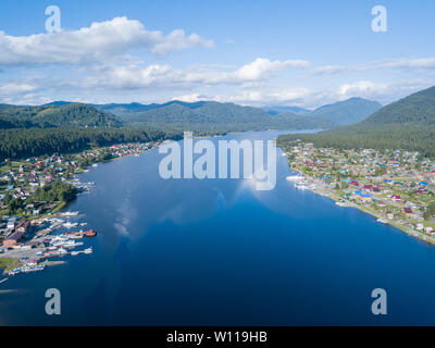 Vue aérienne de l'embouchure dans le lac Teletskoye large dans les montagnes de l'Altaï par l'eau, bleu ciel avec des nuages blancs, vert des arbres sur les pentes de l'un des roches Banque D'Images