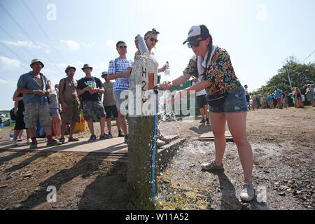 Les festivaliers en attente à un point de remplissage d'eau au festival de Glastonbury, en digne ferme dans Pilton, Somerset. Banque D'Images