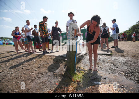 Les festivaliers en attente à un point de remplissage d'eau au festival de Glastonbury, en digne ferme dans Pilton, Somerset. Banque D'Images