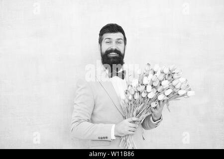 Tulipes pour ma chérie. Homme très soigné porter Bow-tie tuxedo tenir fleurs bouquet. Inviter ses sorties. Homme romantique avec des fleurs. Cadeau romantique. Macho prêt date romantique. En attente de Darling. Banque D'Images