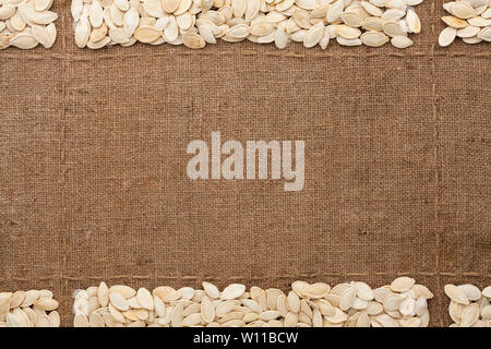 Les graines de citrouille sur de la toile de jute, avec place pour le texte. Vue d'en haut. Copy space Banque D'Images