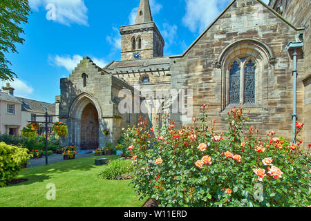 ST ANDREWS FIFE ECOSSE JARDIN DE L'ÉGLISE HOLY TRINITY EN ÉTÉ avec de belles roses et de paniers suspendus de bégonias Banque D'Images