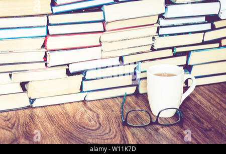 Pile de livres d'étude, des lunettes, et une tasse de thé au citron Banque D'Images