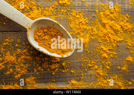 Poudre de curcuma en cuillère en bois sur la table rustique en bois Banque D'Images