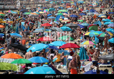 Les gens profiter du soleil et temps chaud sur la plage de Bournemouth dans le Dorset. Banque D'Images
