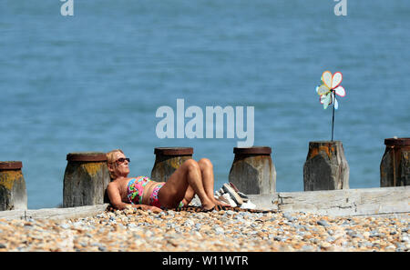 Les gens profiter du beau temps sur la plage à Eastbourne, promenade Sussex. Banque D'Images