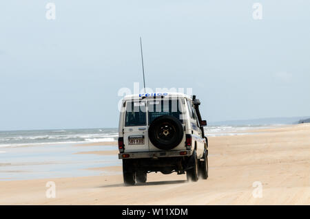 Un véhicule de police patrouille dans le cadre de l'Autoroute 75 km longue plage de sable fin sur la côte est de l'île de Fraser dans le Queensland, Australie. La police s'appliquer Banque D'Images