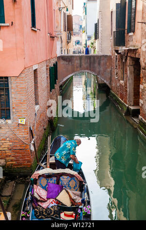 Venise, Italie - Avril 2018 : Gondolier à l'enrôlement d'sa gondole à un magnifique canal à Venise Banque D'Images