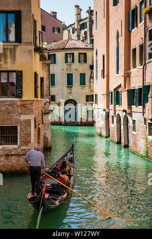 Venise, Italie - Avril 2018 : les touristes naviguant dans une gondole sur les beaux canaux de Venise en un jour au début du printemps Banque D'Images
