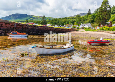 Petit port à Corrie sur l'île d'Arran, Firth of Clyde, en Écosse avec trois petits bateaux au bord de l'eau. Banque D'Images