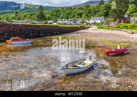 Petit port à Corrie sur l'île d'Arran, Firth of Clyde, en Écosse avec trois petits bateaux au bord de l'eau. Banque D'Images