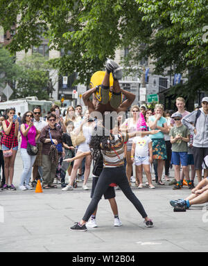 Acrobates de divertir une foule importante par City Hall Park le long de Park Row dans le lower Manhattan. Banque D'Images