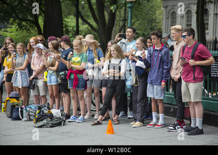 Acrobates de divertir une foule importante par City Hall Park le long de Park Row dans le lower Manhattan. Banque D'Images
