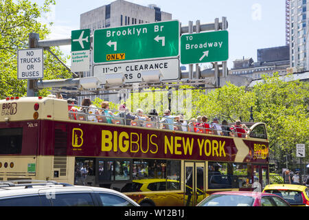 Tour bus à l'entrée du pont de Brooklyn. Les voyages en bus ou à pied, en traversant le pont de Brooklyn est une attraction touristique populaire dans la ville de New York. Banque D'Images