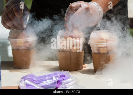 Les mains de l'homme congelé préparer les déserts en utilisant l'azote liquide à festival de la crème glacée. Banque D'Images