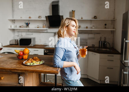 Femme ayant le petit déjeuner avec des croissants et des biscuits Banque D'Images