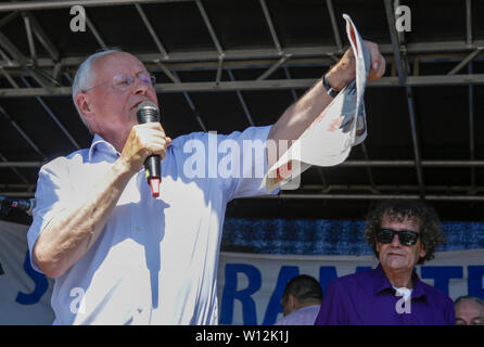 Ramstein, en Allemagne. 29 juin 2019. Oskar Lafontaine, chef de l'opposition à la Sarre pour die Linke (la gauche), s'adresse à la foule lors de la clôture rallye, holding Bild Zeitung.quelques milliers de militants pour la paix à partir de la Base aérienne de Ramstein Stopp a protesté contre la campagne en dehors de la base aérienne de Ramstein US. La protestation a été la fin de cette année, la semaine d'action contre la base aérienne. L'objectif principal de cette année était sur l'implication présumée de la base aérienne dans le drone warfare de l'US Air Force au Moyen-Orient et l'Afrique et l'appel à l'utilisez pas Ramstein pour une future guerre contre l'Iran. Banque D'Images