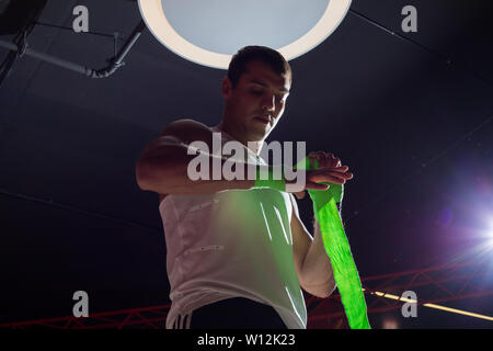 L'homme Sport est dans l'anneau et les moulinets de bandage de boxe. Male boxer. Banque D'Images