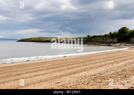Soleil brille pendant une pause dans les nuages sur la plage de sable de l'île de Barry, rayée par les traces de pneus du tracteur, et le frère de faible altitude's point pointe. Banque D'Images