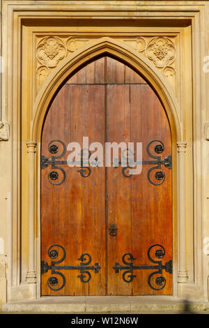 Vieille église en bois cintrées porte avec cadre en pierre et ornements métalliques Banque D'Images