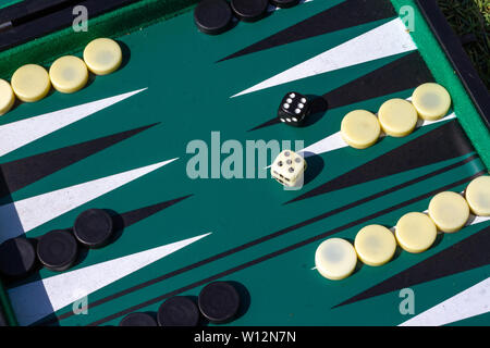 Jeu de backgammon avec la configuration de démarrage et deux dés, un blanc, un noir montrant un six et un cinq Banque D'Images