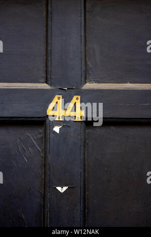 Numéro de maison 44 avec les quarante-quatre chiffres en métal sur une porte en bois Banque D'Images