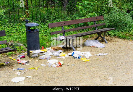 Beaucoup de déchets en plus d'une poubelle et une banque brown dans un parc à Dresde, Allemagne. La litière est probablement dû à certains oiseaux essayant d'obtenir un peu de nourriture Banque D'Images