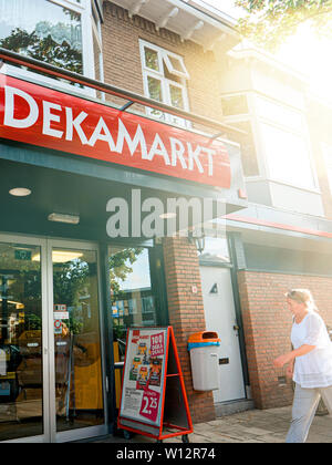 Haarlem, Pays-Bas - Aug 20, 2018 : Vertical image de supermarché DekaMarkt De Luxe entrée avec Dutch femme marche à l'entrée Banque D'Images