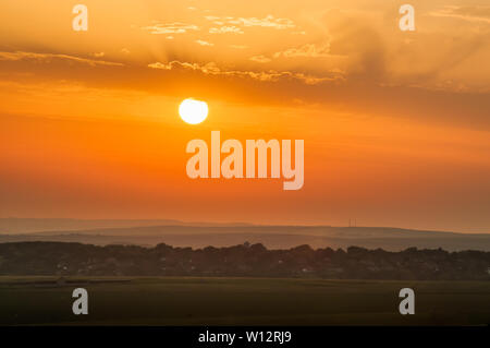 Beachy Head, Eastbourne, East Sussex, Royaume-Uni..26 juin 2019..le soleil se couche sur la campagne alors que la brume de mer se déplace pour adoucir la scène. . Banque D'Images