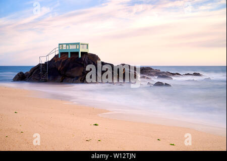 Point de vue ou d'un belvédère sur les rochers sur une plage de Vila do Conde, Portugal, au coucher du soleil. Banque D'Images