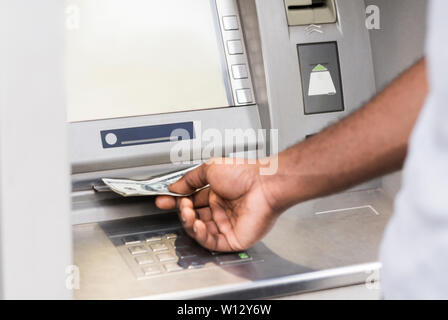 Jeune homme africain méconnaissable obtenir de l'argent au distributeur Banque D'Images