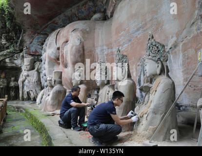 Beijing, Chine. 29 Juin, 2019. Les membres du personnel de vérifier avec des statues à l'appareil à ultrasons Sculptures rupestres de Dazu scenic area dans le district de Dazu de Chongqing, au sud-ouest de la Chine, le 29 juin 2019. Restauration d'une statue de Bouddha à dormir dans le sud-ouest de la municipalité de Chongqing en Chine a commencé. Credit : Huang Shu/Xinhua/Alamy Live News Banque D'Images