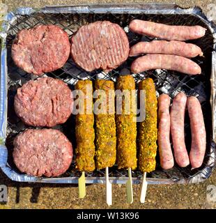 Bac aluminium barbecue instantané jetable ,avec des matières,beefburgers saucisses,brochettes, Banque D'Images