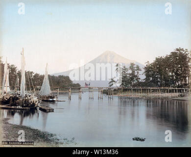 [ 1880 ] Le Japon - Mont Fuji - vue d'Numakawa River et le Mont Fuji vu de Tagonoura dans la préfecture de Shizuoka. Tagonourabashi pont, construit en 1873, ainsi que plusieurs bâtiments à voile peut être vu. Un pousse-pousse avec le client est de traverser le pont. Depuis la porte de pierre pour bloquer le flux de retour est manquant dans la partie intérieure du port, cette photographie doit avoir été prise avant 1886. 19e siècle vintage albumen photo. Banque D'Images