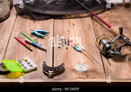 Les hameçons, les appâts et les outils pour la pêche. Attirail de pêche sur une jetée en bois. Banque D'Images