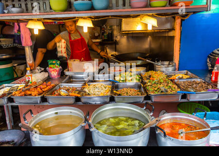 Bangkok, Thaïlande - 12 Avril 2019 : la cuisson et la vente d'une grande variété de plats thaïlandais bon marché dans un restaurant de rue à Bangkok Banque D'Images