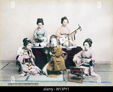 [ 1890 - Japon ] - Lecture de musique Maiko Maiko en kimono et coiffures traditionnels pratiquent le chant ainsi que de jouer tsutsumi (également tsuzumi) batterie, l'épaule d'un shamisen, instrument de musique à trois cordes, un tambour taiko connu comme ootsutsumi et une flûte de fue. 19e siècle vintage albumen photo. Banque D'Images