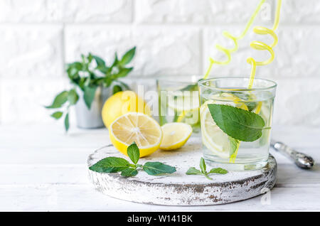 Mojito cocktail dans le verre, les citrons et les feuilles de menthe en bascet sur table en bois blanc, cocktail boissons d'été concept Banque D'Images