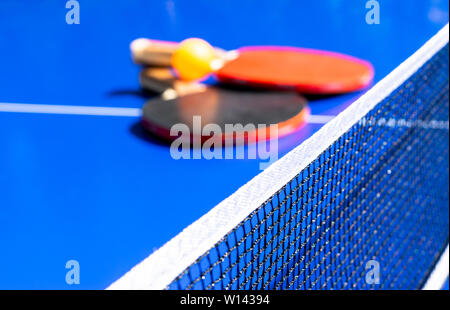 Blue tennis de table ou ping-pong. Close-up filet de ping-pong. Close up ping pong net et ligne. Deux tennis de table ou de raquettes de ping-pong ou des palettes et de balle sur Banque D'Images